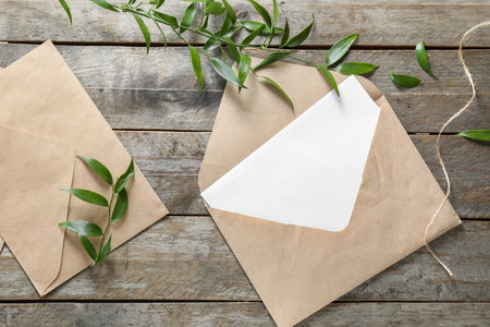 Composition with blank card and envelopes on wooden background