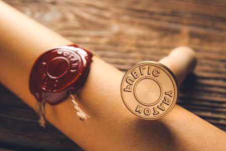 Scroll with notary public wax seal on table, closeup