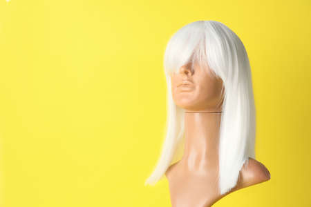 Mannequin with female wig on color backgroundの写真素材