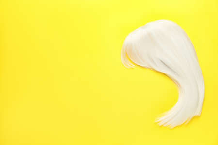 Female wig on color background