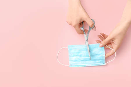 Woman making medical mask on color backgroundの写真素材