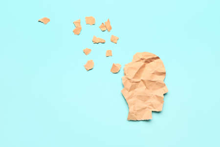 Torn paper human head on color background. Concept of dementiaの写真素材