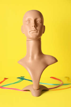 Mannequin and fake hair strands on color backgroundの写真素材