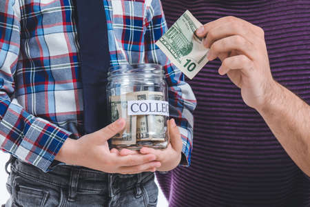 Little boy and father with money in jar, closeup. Concept of savings for educationの写真素材