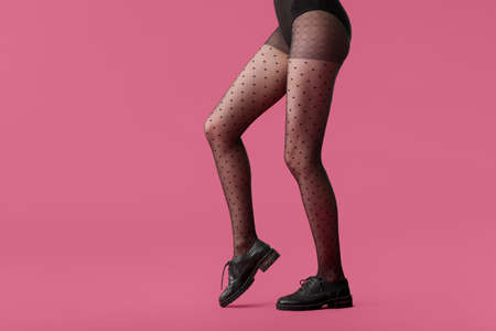 Legs of beautiful young woman in tights on color backgroundの写真素材