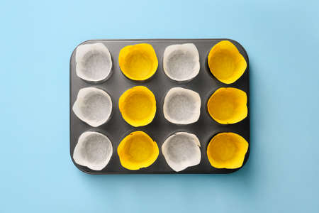 Muffin baking cups with tray on color backgroundの写真素材