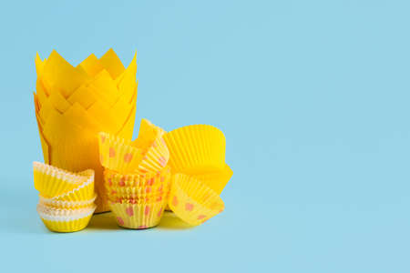 Muffin baking cups on color background