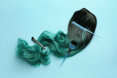 Unusual wig with hairdresser supplies on color backgroundの写真素材