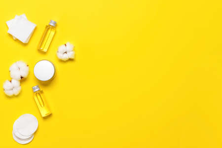 Cotton flowers with cosmetics and pads on color backgroundの写真素材