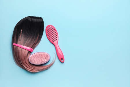 Unusual wig with hairdresser supplies on color backgroundの写真素材