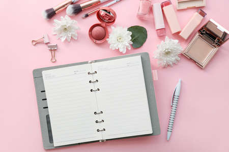 Different stationery with makeup cosmetics on color background