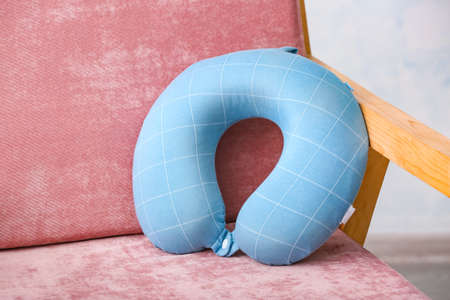 Travel pillow in armchair at homeの写真素材