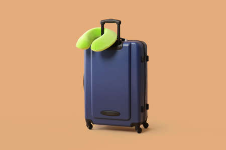 Packed suitcase and travel pillow on color background