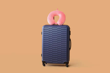 Packed suitcase and travel pillow on color backgroundの写真素材
