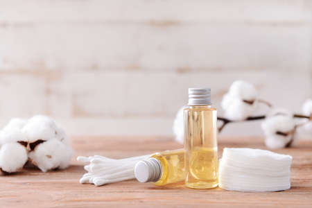 Bottles of cottonseed oil with cosmetic pads and swabs on tableの写真素材