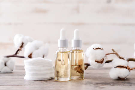Bottles of cottonseed oil with cosmetic pads on tableの写真素材