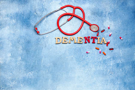 Word DEMENTIA with pills and stethoscope on color backgroundの写真素材