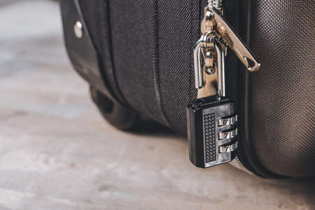 Suitcase with lock on gray background, closeup