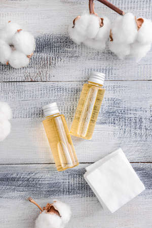 Bottles of cottonseed oil with cosmetic pads on tableの写真素材