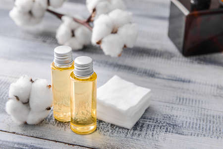 Bottles of cottonseed oil with cosmetic pads on tableの写真素材