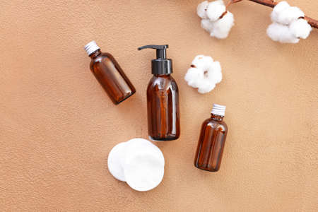 Bottles of cottonseed oil with cosmetic pads on color backgroundの写真素材