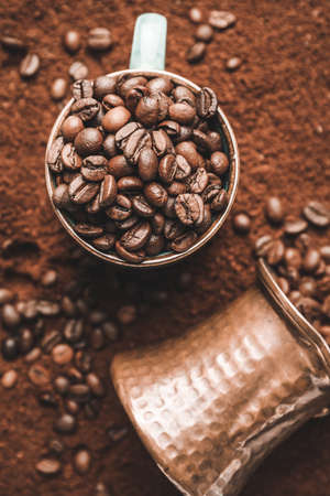 Cup with coffee beans and jezve on powderの写真素材