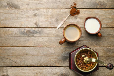 Hot coffee, milk and grinder on wooden backgroundの写真素材