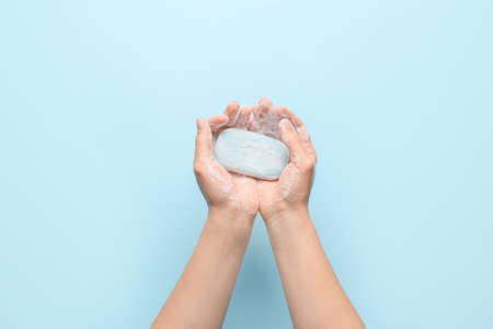 Woman washing hands on color backgroundの写真素材