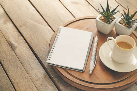 Composition with notebook and cup of coffee on wooden background