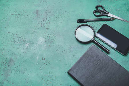 Office supplies with mobile phone on color background