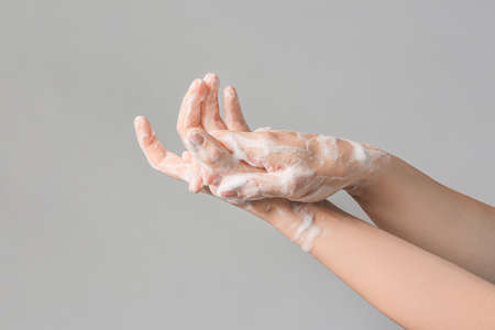Woman washing hands on gray backgroundの写真素材