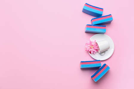 Clean dish, cup and sponges on color backgroundの写真素材