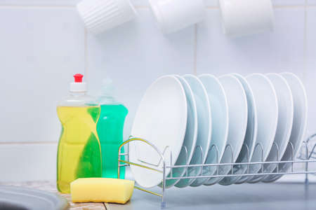 Clean dishes and detergents on kitchen table
