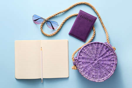 Notebook with bag, passport and sunglasses on color backgroundの写真素材