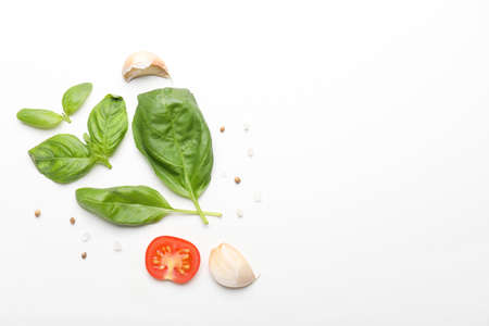 Composition with basil, tomatoes and spices on white backgroundの写真素材