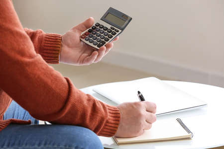 Senior man calculating expenses at home