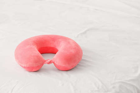 Travel pillow on bed in roomの写真素材