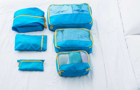 Set of travel organizers with belongings on bed at homeの写真素材