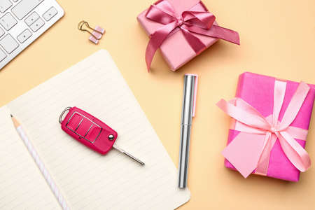 Gift boxes with car key and stationery on table