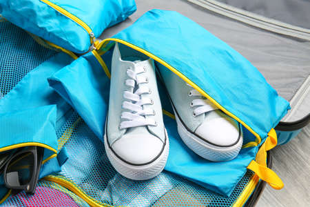 Suitcase and set of travel organizers with belongings, closeupの写真素材