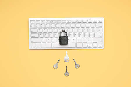 Computer keyboard with padlock and keys on color background