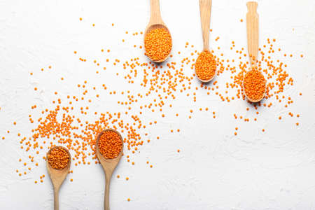 Spoons with red lentils on light backgroundの写真素材