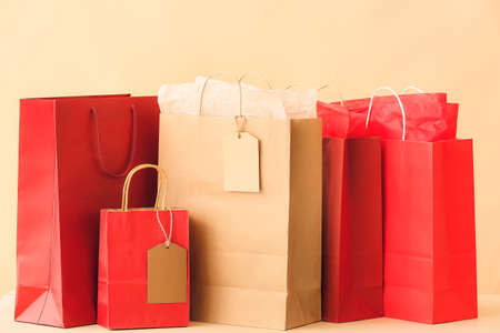 Paper shopping bags on color background