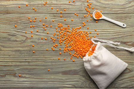 Composition with red lentils on wooden background