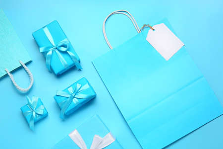 Paper shopping bags and gifts on color backgroundの写真素材