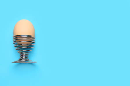 Holder with chicken egg on color backgroundの写真素材