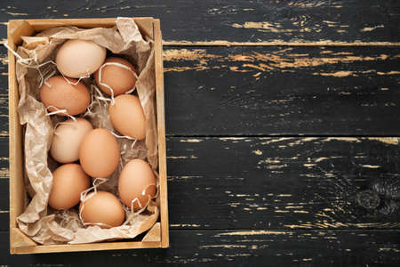 Box with chicken eggs on wooden backgroundの写真素材