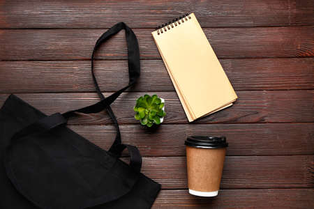 Eco bag with cup of coffee and notebook on wooden backgroundの写真素材