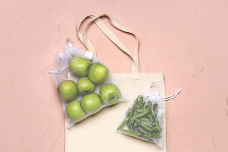 Eco bags with fresh products on color backgroundの写真素材