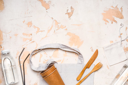 Eco bags with cups, cutlery and bottles of water white backgroundの写真素材